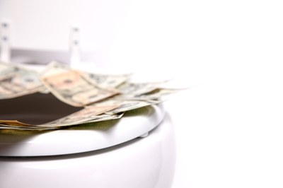 Descrição da imagem #PraCegoVer: notas de dinheiro em cima de vaso sanitário. Fonte: Istock. 