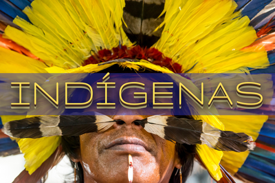Fotografia de indígena com cocar de penas coloridas. Ao centro há a palavra “Indígenas” em letras garrafais
