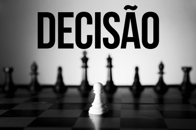 Arte retangular sobre foto de um jogo de xadrez em preto e branco. Está escrito decisão na parte superior.