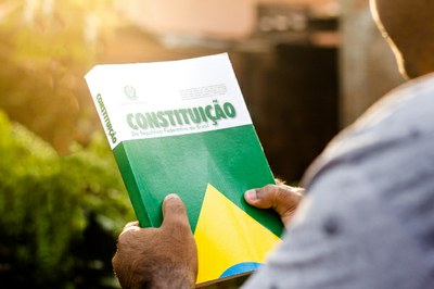 #paratodosverem: foto mostra duas mãos segurando um exemplar da Constituição Federal brasileira.