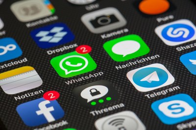 Foto da tela de um celular com vários ícones de aplicativos e o whatsapp em destaque ao centro
