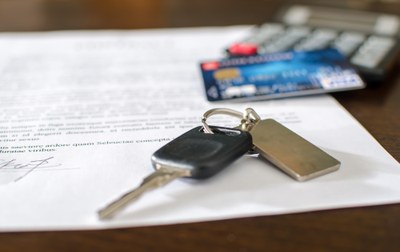 Imagem ilustrativa de mesa com chave de um carro, contrato e cartão de crédito.