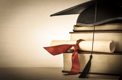 Diploma e barrete sobre fundo branco