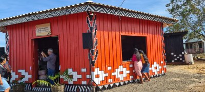#Pratodosverem: Imagem de uma casa de madeira,na cor laranja, ricamente decorada com motivos étnicos 