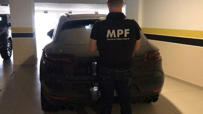 #pracegover: foto de um carro de luxo, com servidor do MPF à frente, com uniforme do MPF. A foto é da Assessoria de Comunicação do Ministério Público Federal.