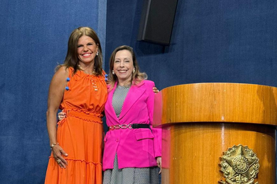 Procuradora Eunice Dantas em foto posada, sorrindo, ao lado a procuradora-geral da República Elizeta Ramos. As duas vestem roupas em tons vibrantes, sendo Eunice laranja e Elizeta rosa.