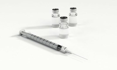 Foto ilustrativa mostra três frascos de remédio e uma seringa 