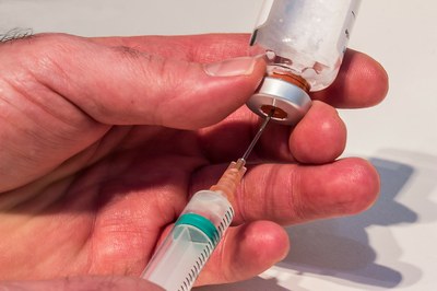 #pratodosverem: foto colorida que mostra uma pessoa usando uma seringa para retirar medicamento de um frasco.