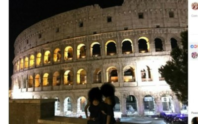 Duas pessoas posando para foto com o rosto apagado em frente ao Coliseu, em Roma