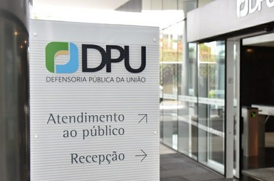 Foto de uma placa indicativa, na qual se lê: DPU - Defensoria Pública da União / Atendimento ao Público / Recepção