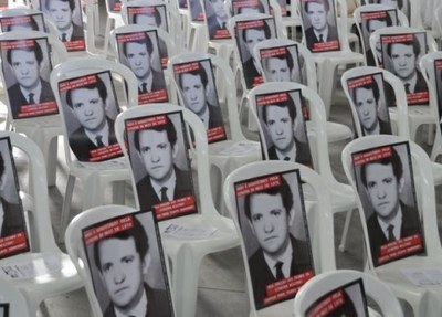 Fotos de Olavo Hanssen, adesivadas nos apoios de cadeiras, são exibidas durante homenagem ao militante em 2013