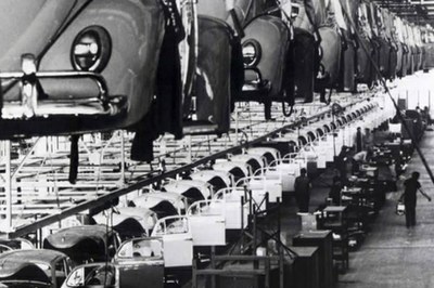 #pracegover: foto em preto e branco da antiga linha de montagem de automóveis Volkswagen, os Fuscas. a foto é da volkswagen.