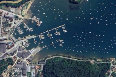 Imagem aérea da região ocupada pelo Centro Náutico Timoneiro no Porto Ribeira, no Saco da Ribeira. É possível ver a área de mar e o entorno à ocupação.