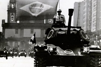 #Paratodosverem: foto de época mostra soldado em tanque de guerra com bandeira do Brasil durante desfile militar. a foto é do Arquivo Nacional.