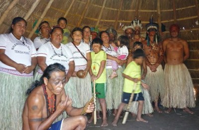 Foto de integrantes da aldeia Tekoá Porã dentro de uma oca