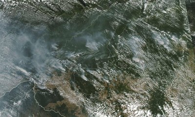 Foto aérea, tirada do espaço, mostra fumaça de queimadas sobre o território brasileiro